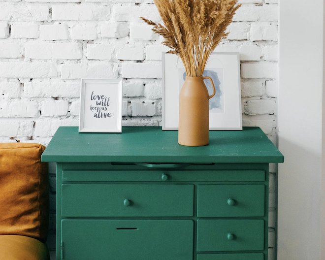 an image of a green drawer with a vase on top of it
